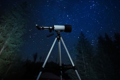 Photo of Modern telescope at night outdoors. Learning astronomy
