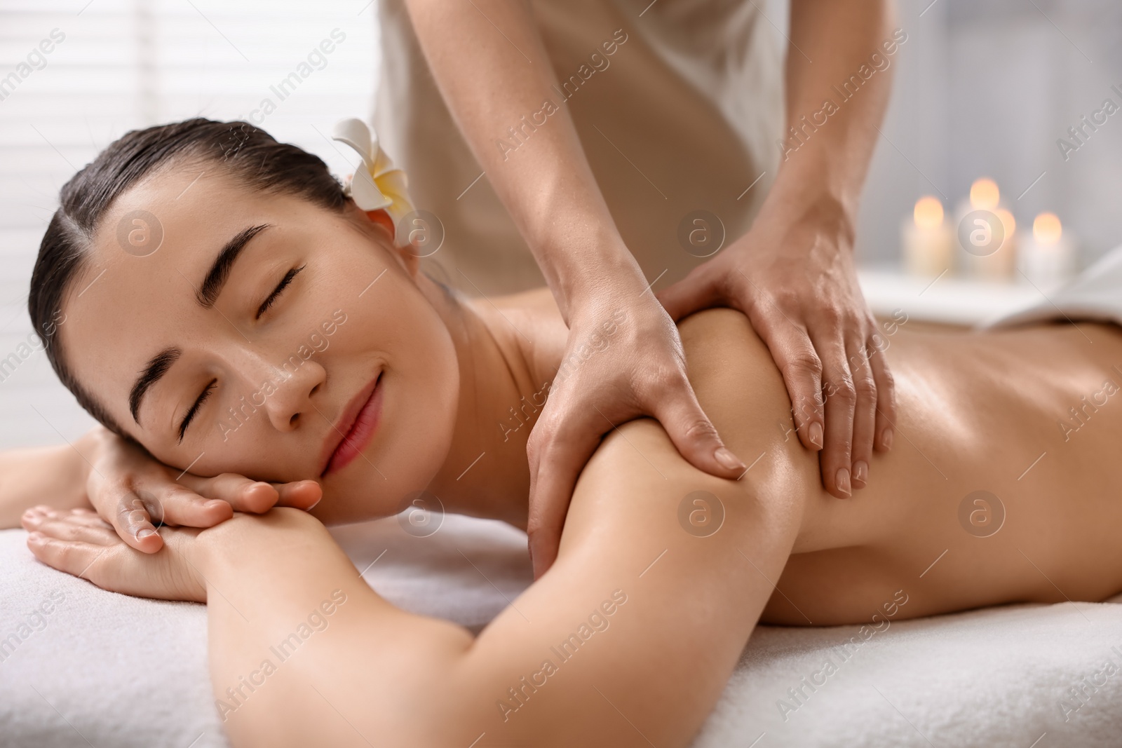 Photo of Woman receiving massage on couch in spa salon