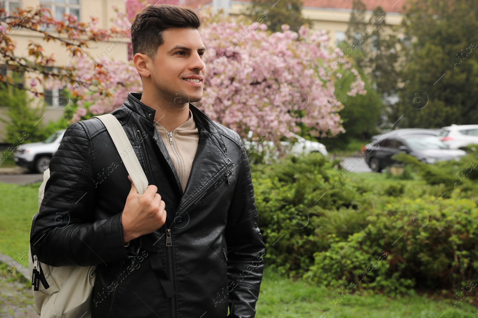 Photo of Tourist with stylish backpack walking on city street