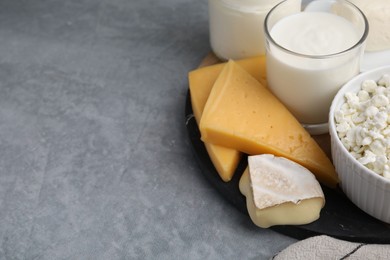 Different fresh dairy products on grey table, space for text