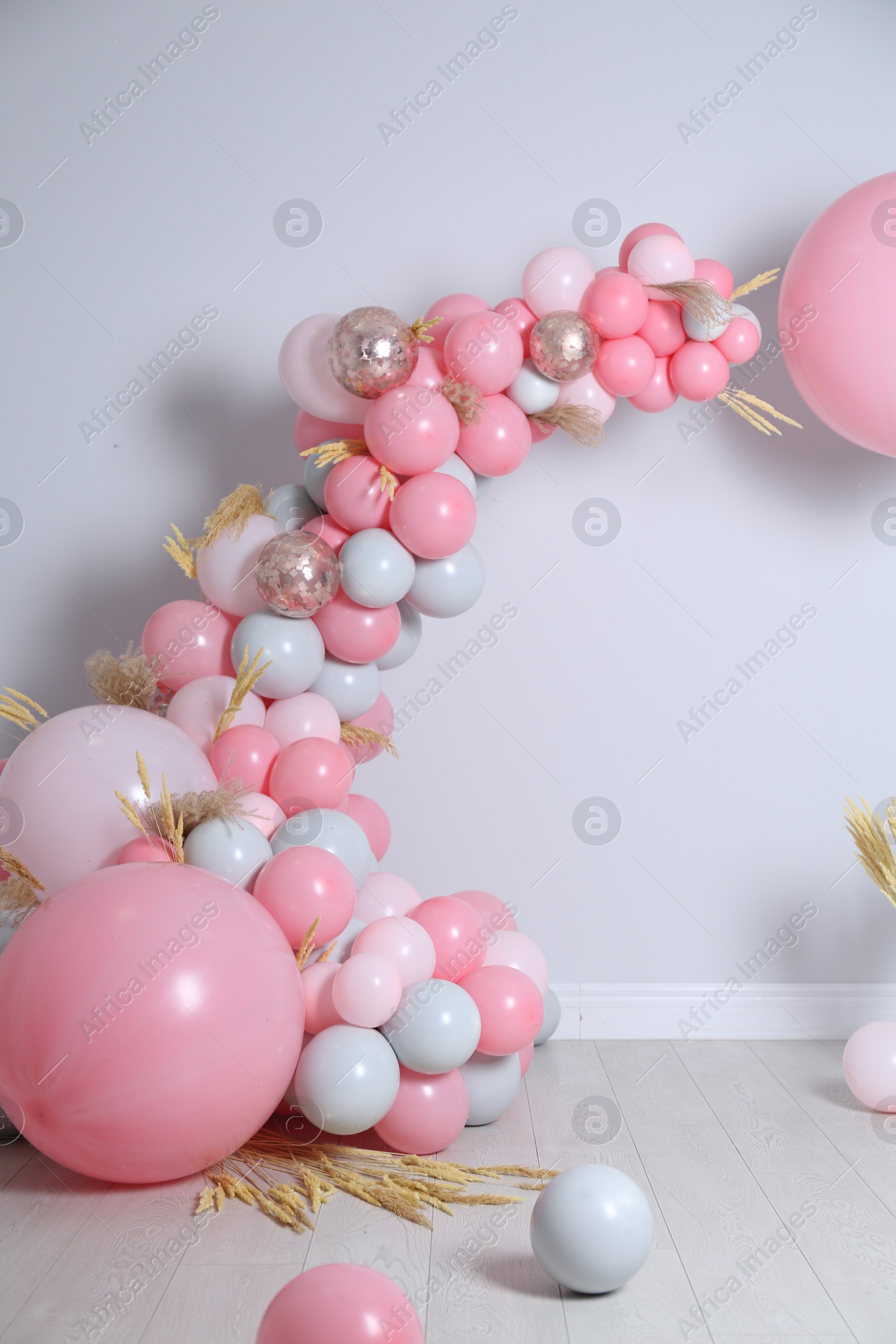 Photo of Beautiful composition with balloons and spikelets near light wall