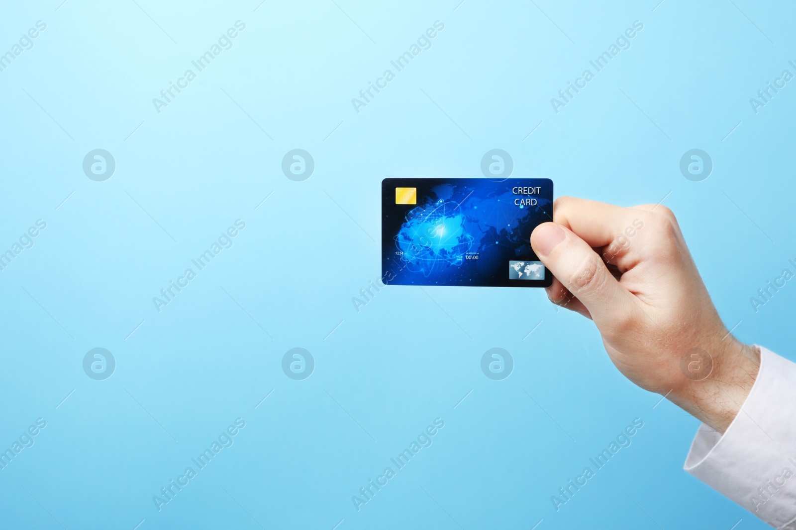 Photo of Young man holding credit card on color background