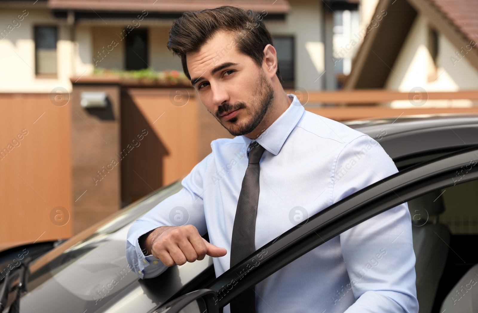 Photo of Attractive young man near luxury car outdoors