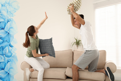 Happy couple having pillow fight in living room