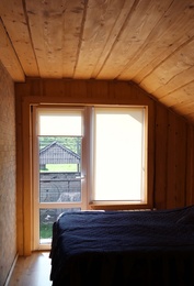 Photo of Window with roller curtains in bedroom on sunny day