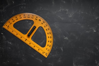 Photo of Protractor with measuring length and degree markings on blackboard, top view. Space for text