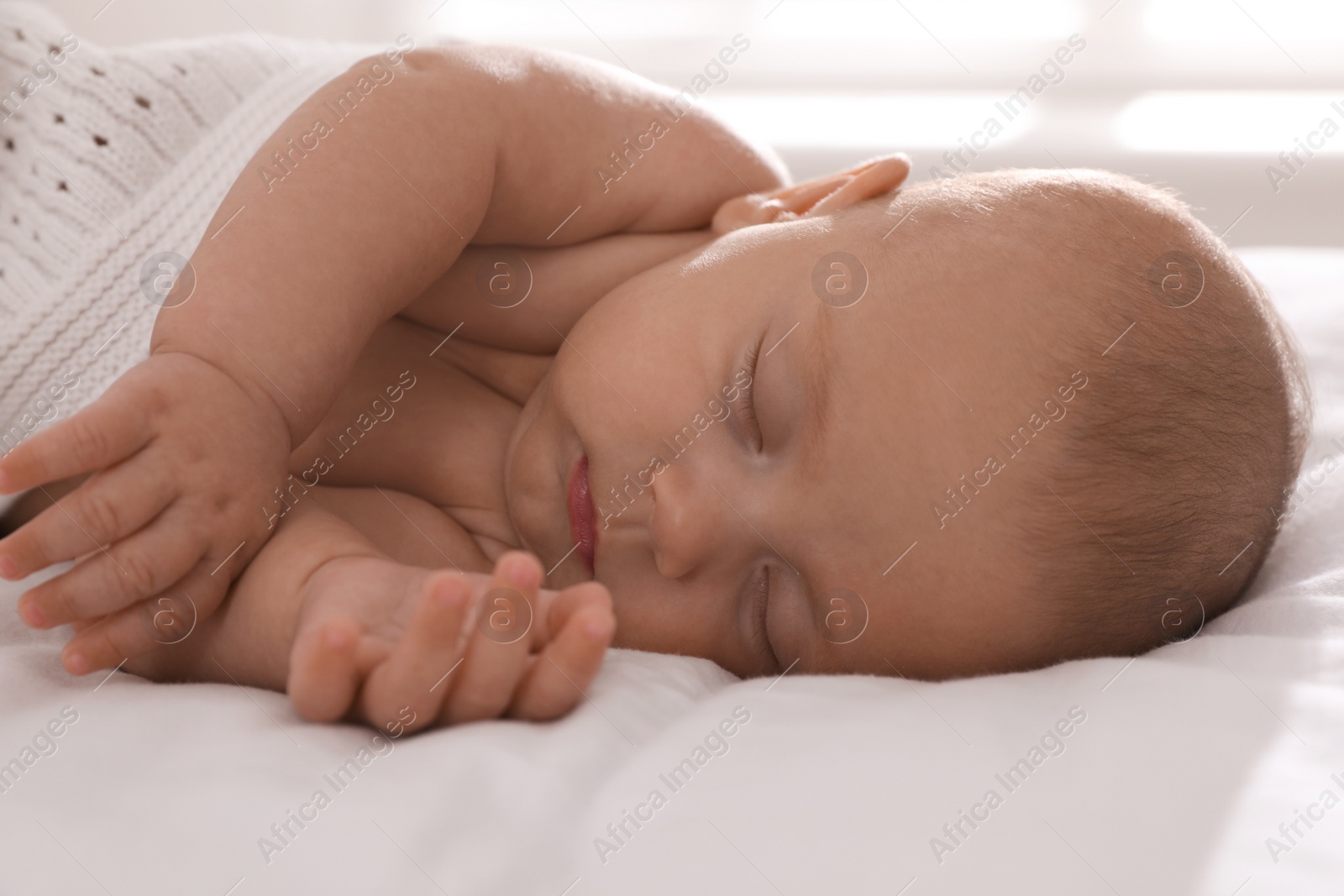 Photo of Cute little baby sleeping in bed, closeup