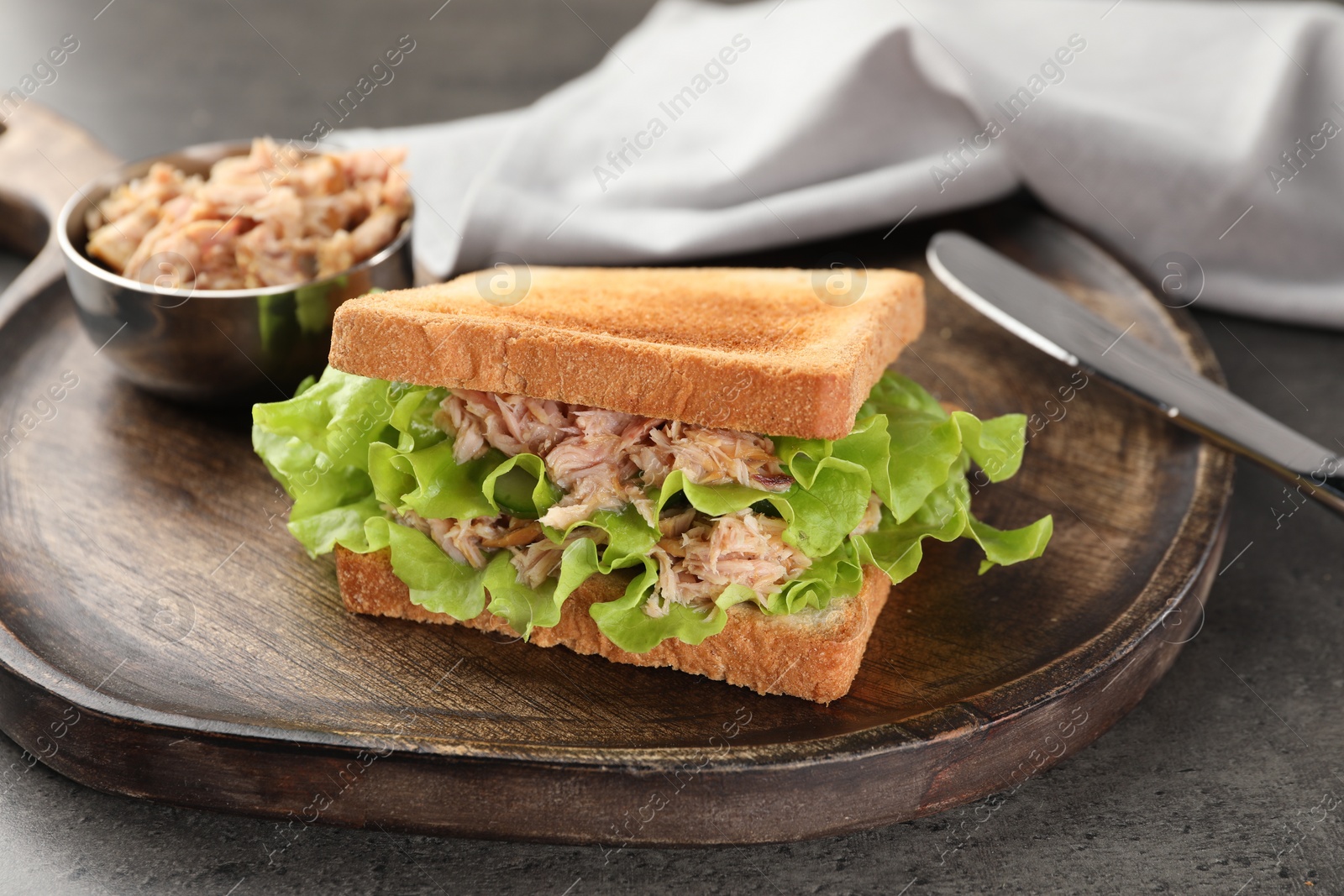 Photo of Delicious sandwich with tuna, lettuce leaves and cucumber on light grey table