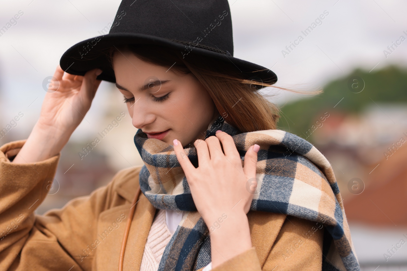 Photo of Beautiful woman in warm scarf and hat outdoors