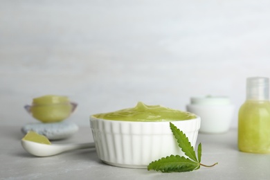 Photo of Bowl of moisturizing hemp lotion on table