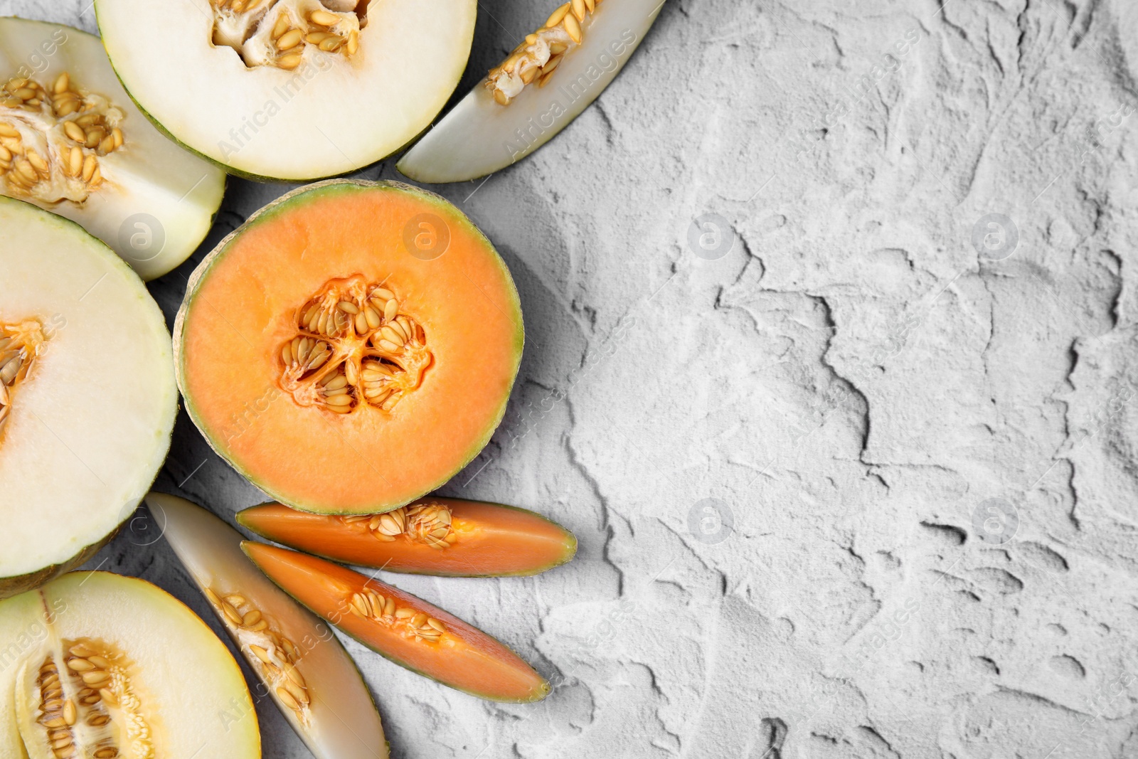 Photo of Tasty colorful ripe melons on white textured background, flat lay. Space for text