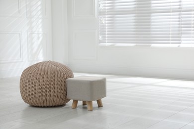 Photo of Stylish pouf and ottoman in room. Home design, space for text