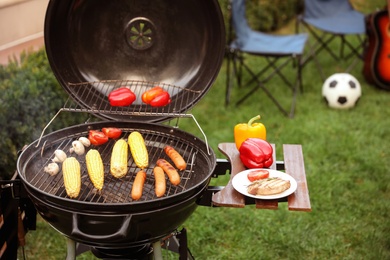 Photo of Barbecue grill with tasty fresh food outdoors