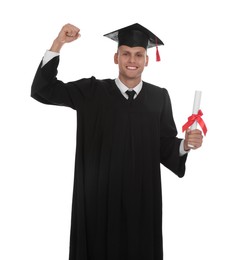 Happy student in academic dress with diploma on white background