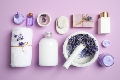 Cosmetic products and lavender flowers on lilac background, flat lay