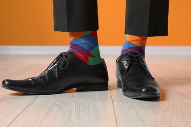 Photo of Man wearing stylish shoes and colorful socks indoors, closeup
