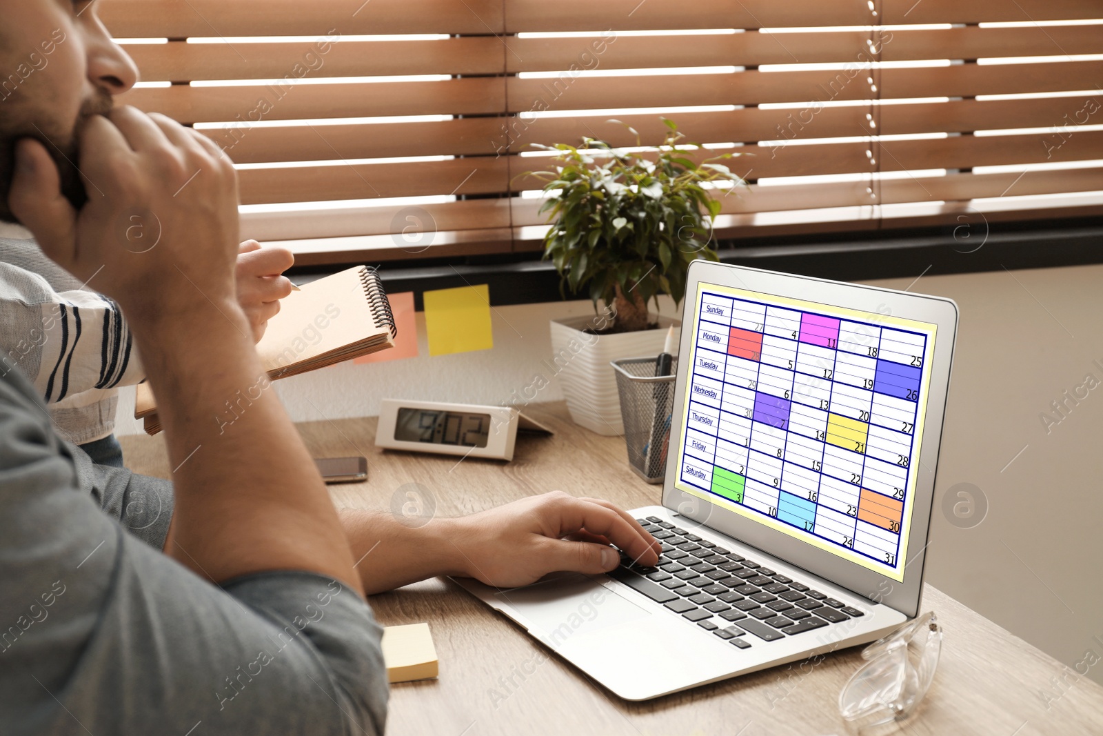 Photo of Colleagues working with calendar app on laptop in office, closeup