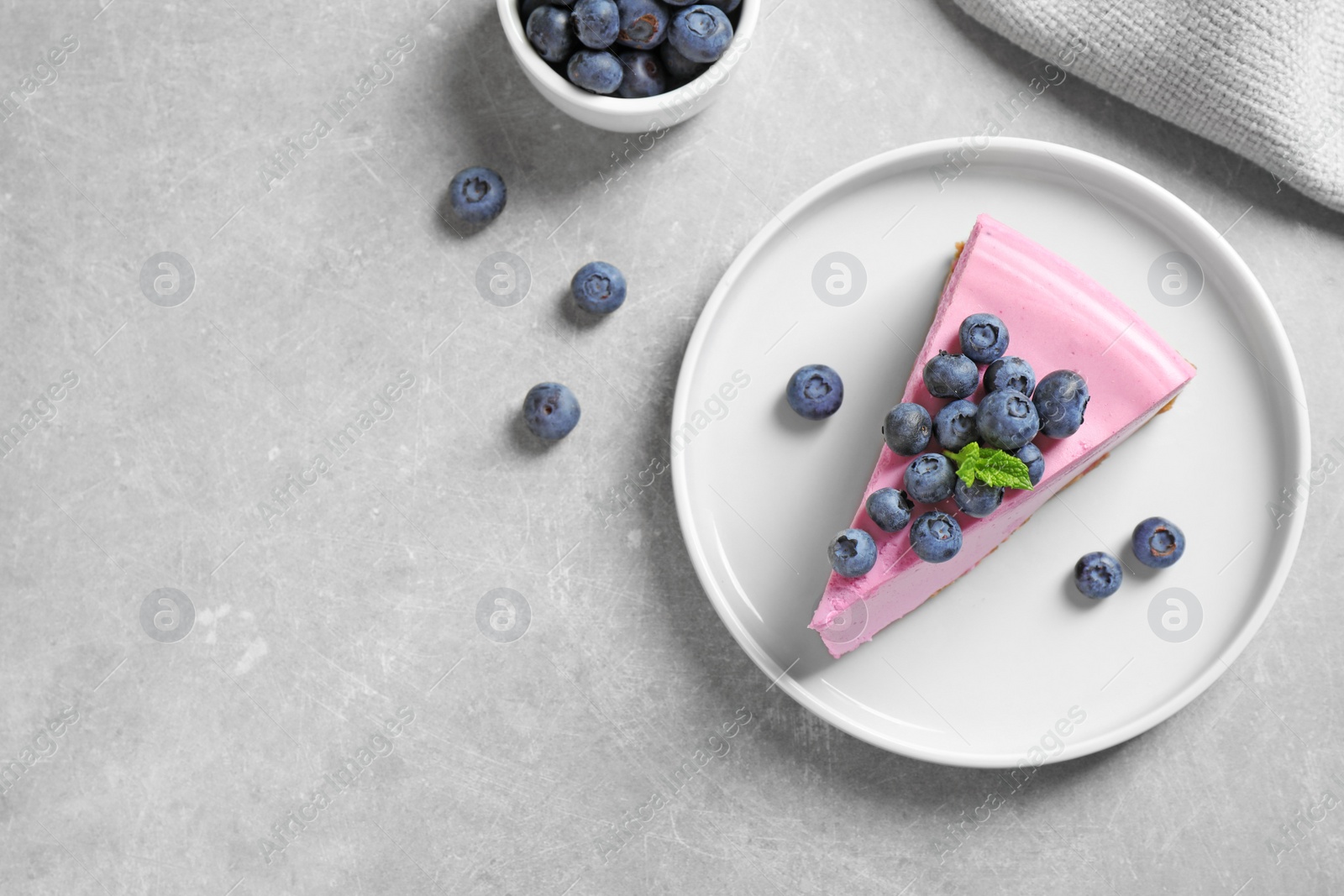 Photo of Plate with piece of tasty blueberry cake on light table, flat lay. Space for text