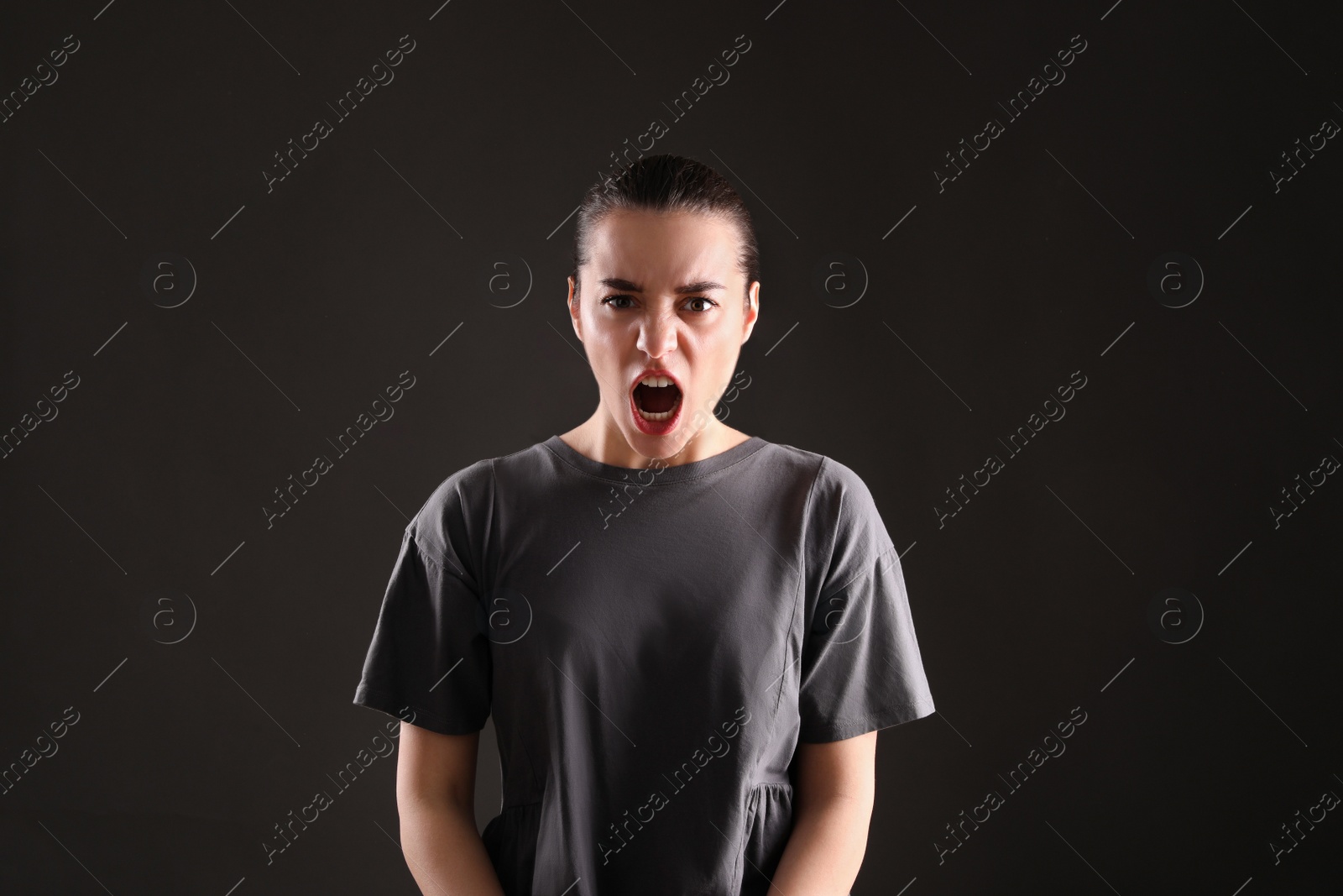 Photo of Portrait of emotional young woman on black background. Personality concept