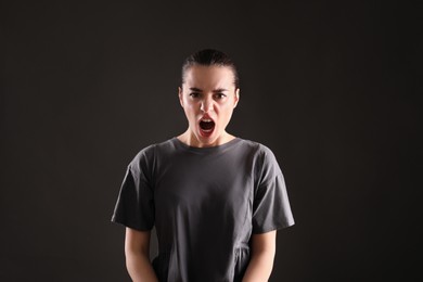 Photo of Portrait of emotional young woman on black background. Personality concept