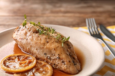 Photo of Baked lemon chicken with thyme served on table, closeup