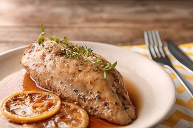 Baked lemon chicken with thyme served on table, closeup