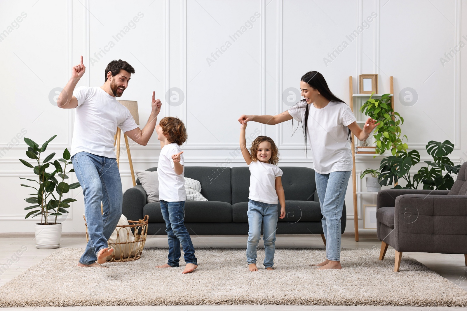 Photo of Happy family dancing and having fun in living room