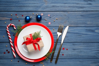 Beautiful Christmas table setting on blue wooden background, flat lay. Space for text