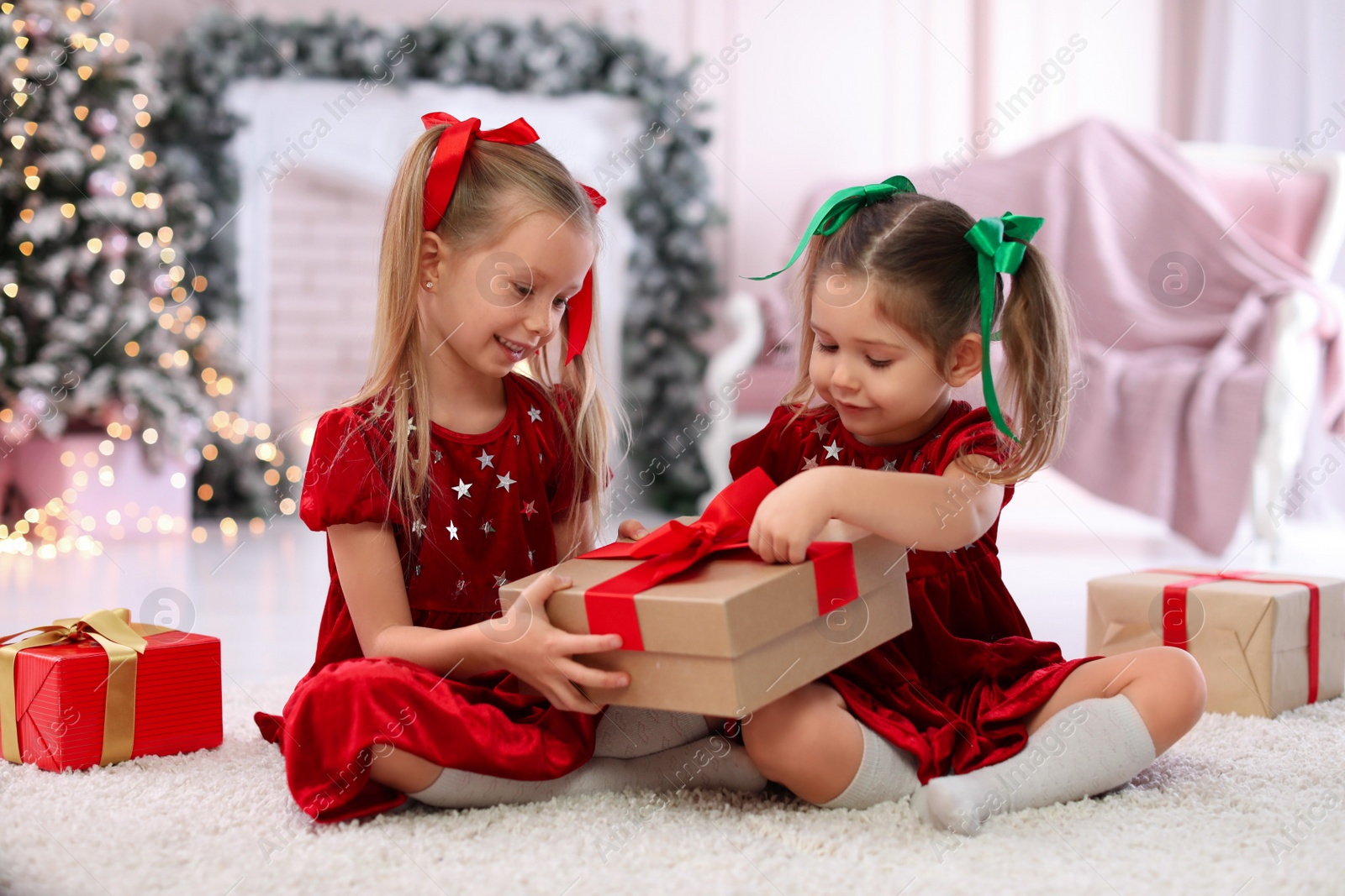 Photo of Cute little children with Christmas gifts at home