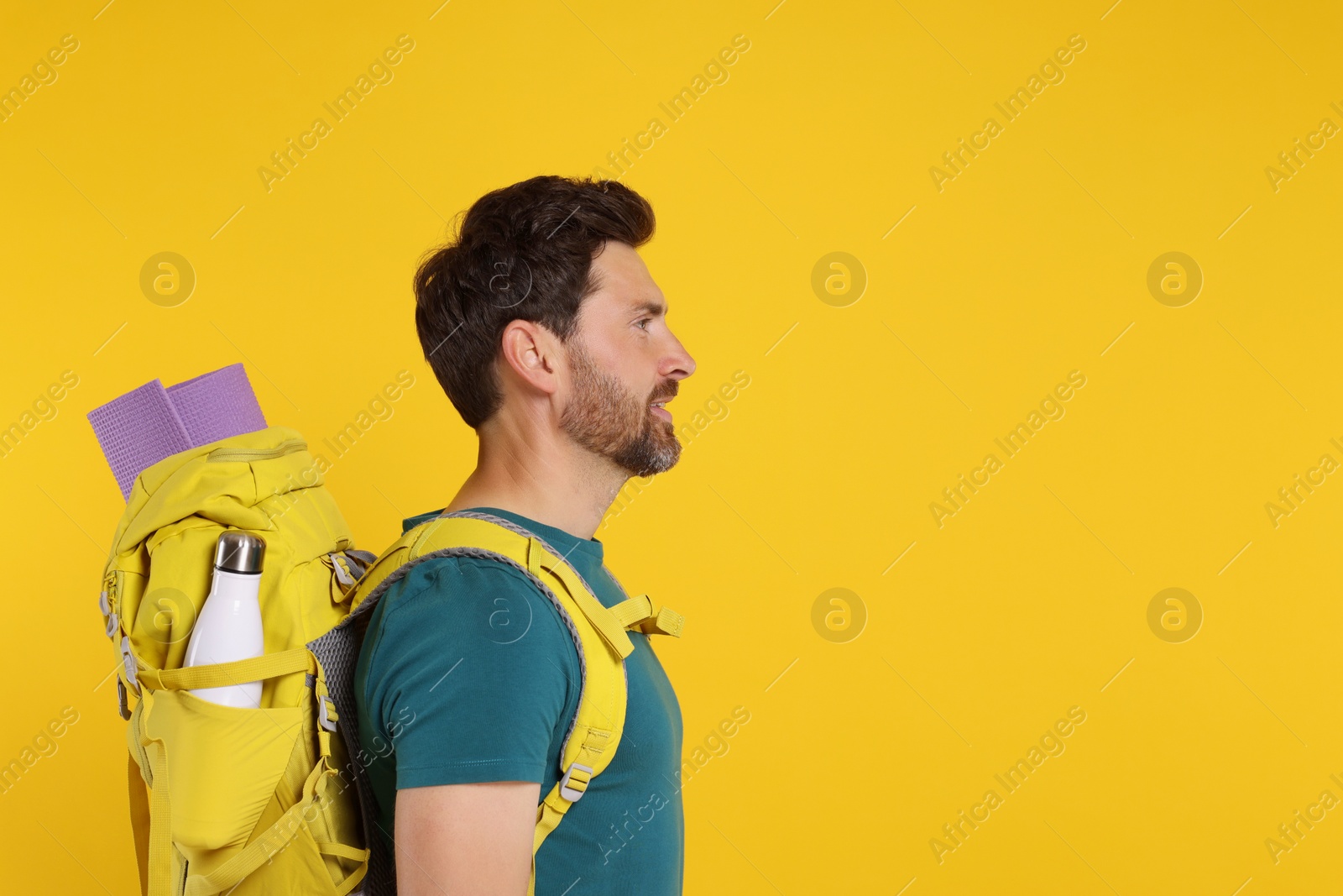 Photo of Man with backpack on orange background, space for text. Active tourism