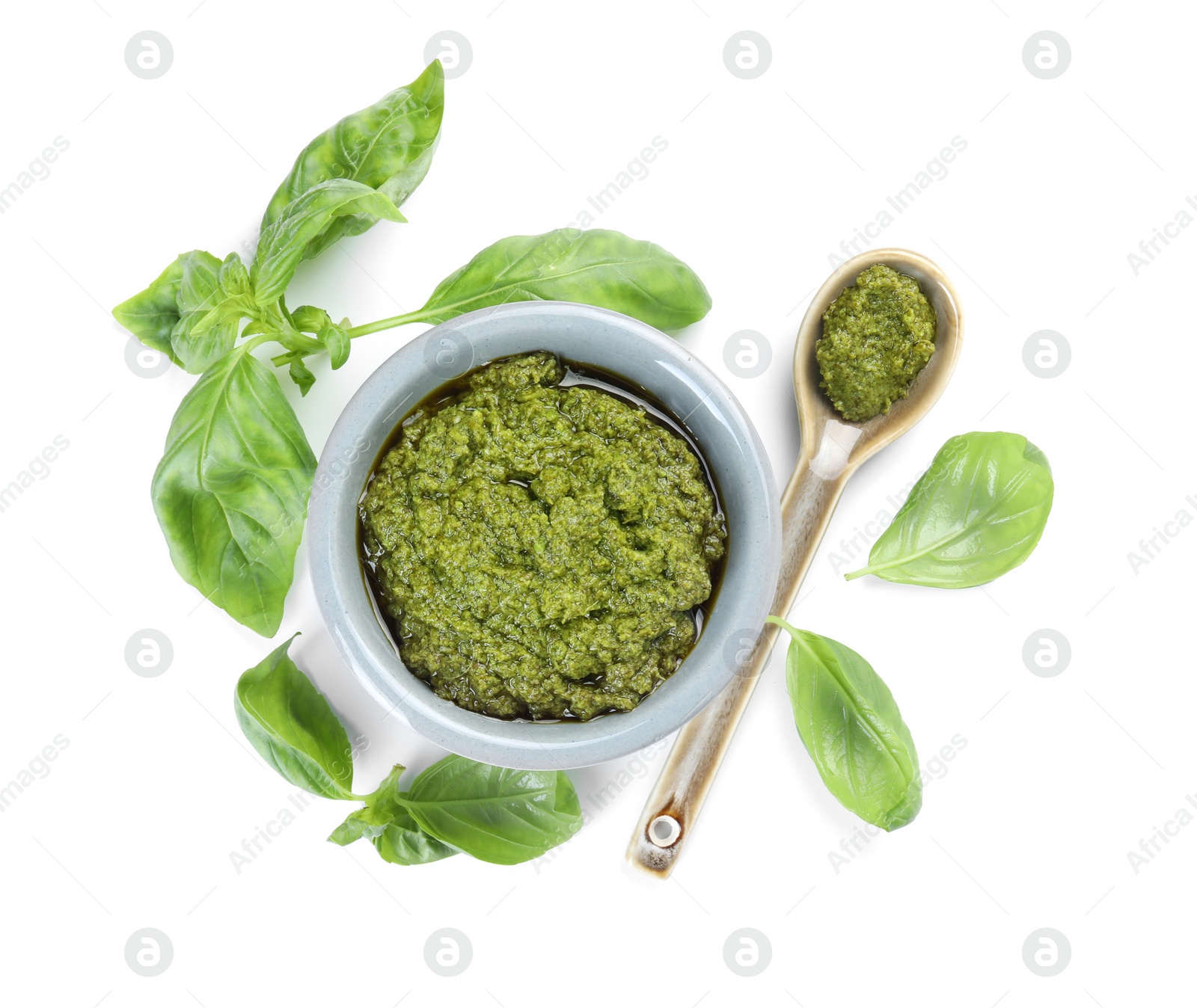 Photo of Fresh tasty pesto sauce and basil isolated on white, top view