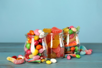Photo of Jars with different delicious candies on turquoise wooden table