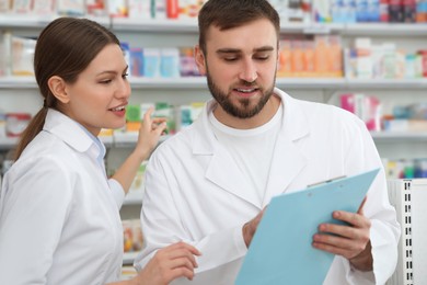 Photo of Professional pharmacists working together in modern drugstore