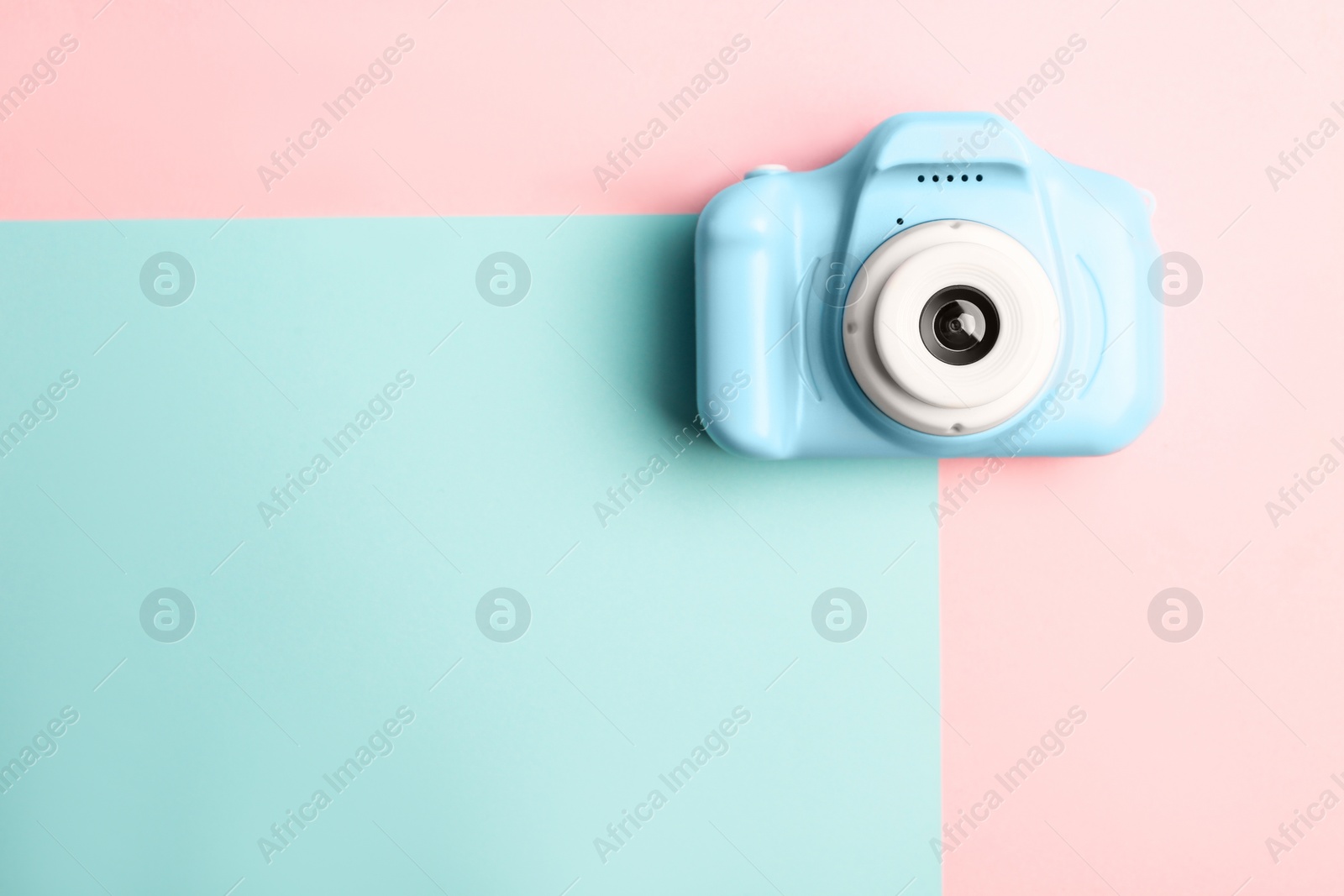 Photo of Light blue toy camera on color background, top view with space for text. Future photographer