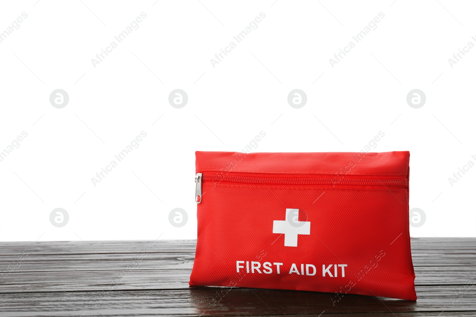 Photo of First aid kit on wooden table against white background