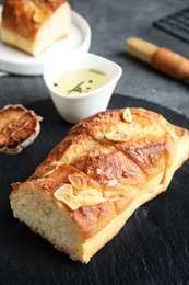 Slate plate with homemade garlic bread on table