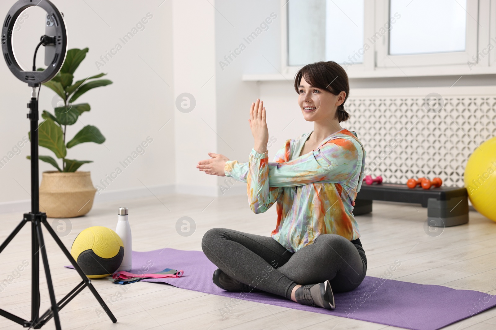 Photo of Happy sports blogger streaming online fitness lesson at home