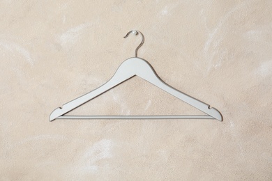 Photo of Empty clothes hanger on color wall. Wardrobe accessory