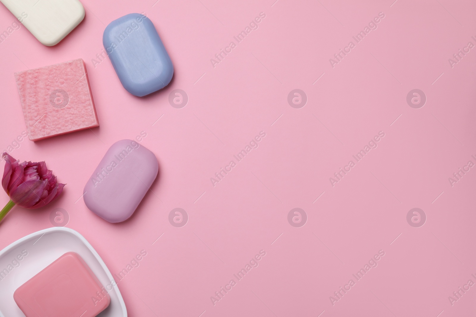 Photo of Many soap bars on pink background, flat lay. Space for text
