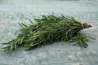 Photo of Bunch of fresh rosemary on light blue wooden table