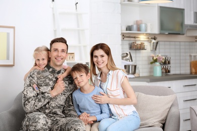 Man in military uniform with his family on sofa at home