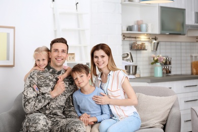 Photo of Man in military uniform with his family on sofa at home