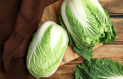 Fresh ripe Chinese cabbages on wooden table, flat lay
