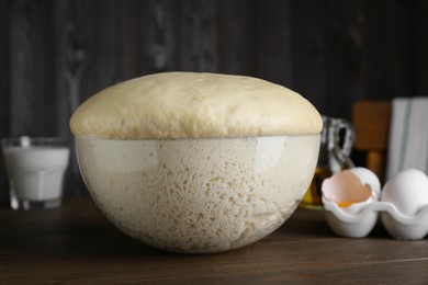Fresh yeast dough and ingredients on wooden table