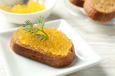 Slice of bread with pike caviar on white wooden table, closeup