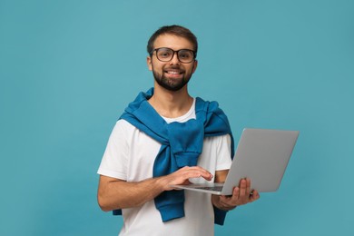 Photo of Student using laptop on light blue background