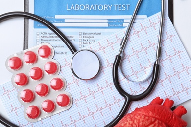 Photo of Flat lay composition with stethoscope and pills on table. Cardiology service