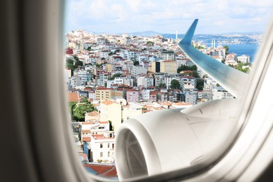 Image of Beautiful city and sea, view through airplane window during flight