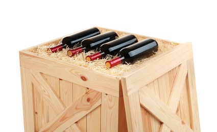 Photo of Wooden crate with bottles of wine isolated on white, closeup