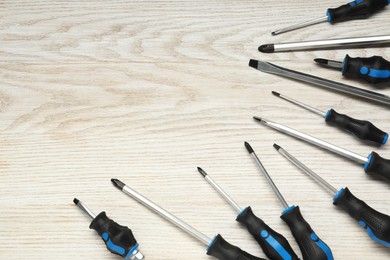 Photo of Set of screwdrivers on wooden table, above view